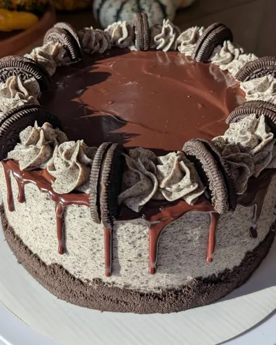 A dark chocolate Oreo birthday cake with a chocolate ganache drip, cookies-and-cream buttercream rosettes, and a ring of Oreo cookies pressed around the top edge